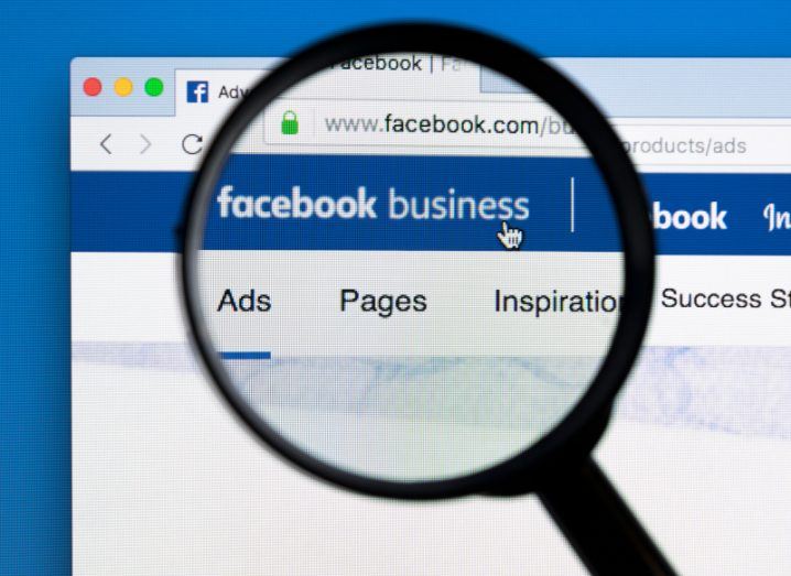 A magnifying glass over a web page that has Facebook Business written on it.