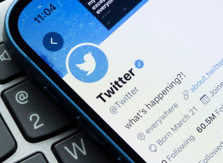 Twitter's own Twitter page is shown on a smartphone screen, with the tagline 'What's happening' written in its profile description.