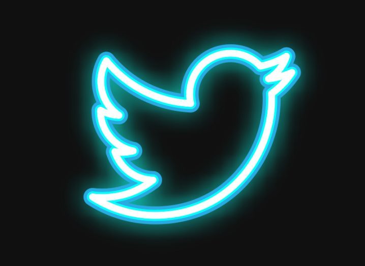 A neon outline of the Twitter bird logo against a black background.