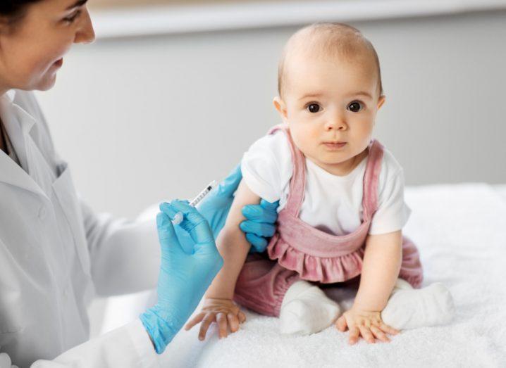 Baby being vaccinated by a doctor.