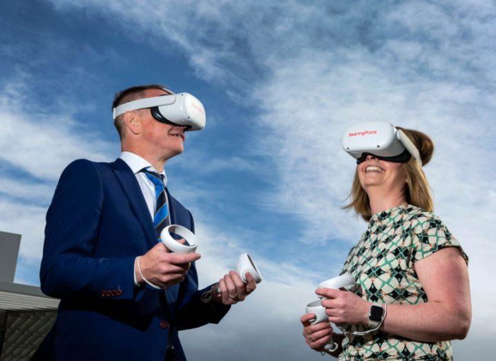 A man and a woman wearing VR headsets and looking upwards while exploring the metaverse.