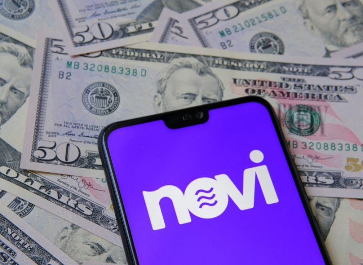 The Novi logo on a smartphone placed on fifty-dollar notes.