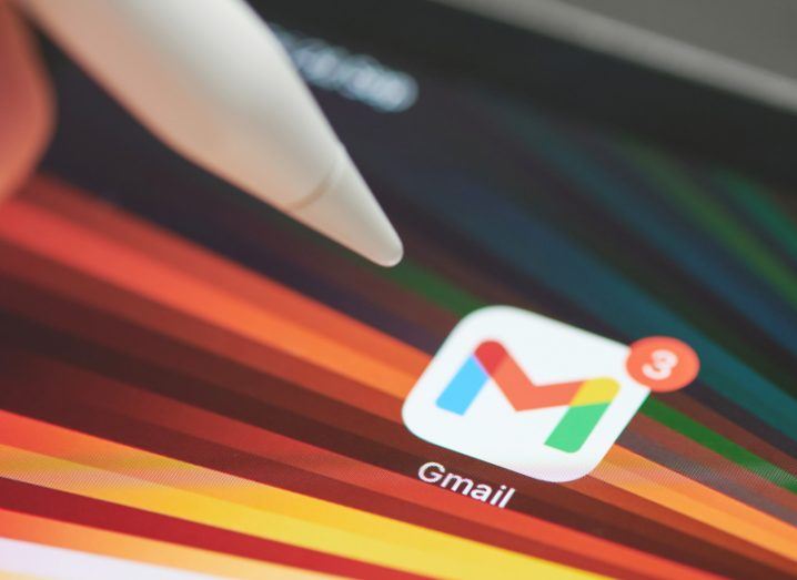 A pen moving toward a Gmail logo on a screen.