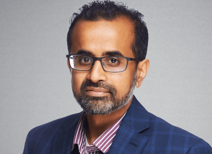 A headshot of a man against a grey background. He is Saket Srivastava, CIO of Asana.