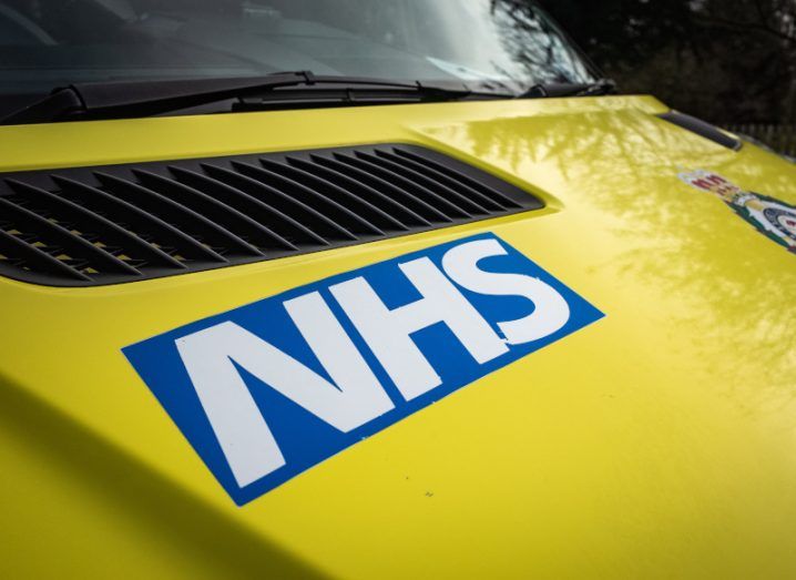 NHS logo on a yellow ambulance in the UK.