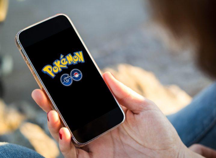 Pokemon Go app logo displayed on a mobile screen held in a person's hand.