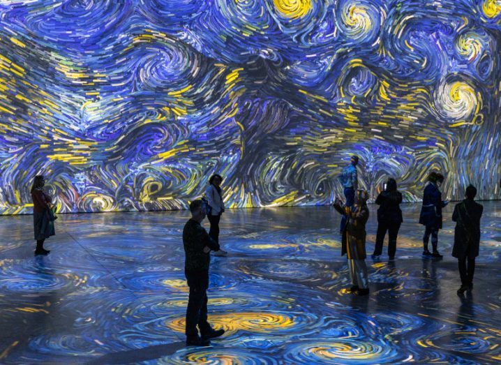 Van Gogh painting Starry Night displayed at the exhibition in Dublin with people standing around.