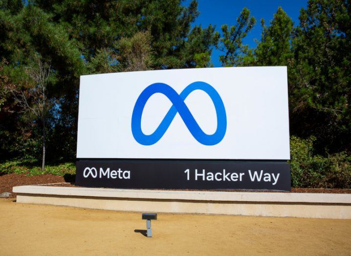 Meta logo on a sign in an open area with trees in the background.