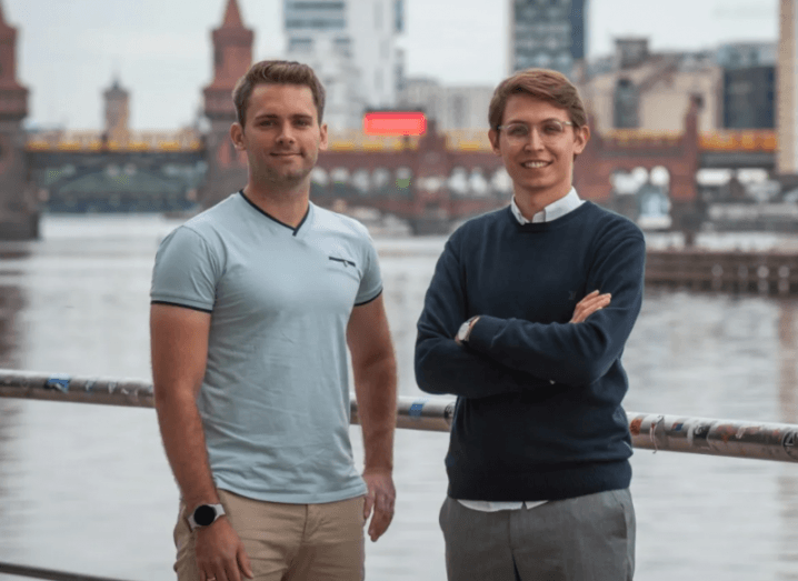 Two men standing next to each other with a river and buildings in the background. They are the co-founders of LiveEO.