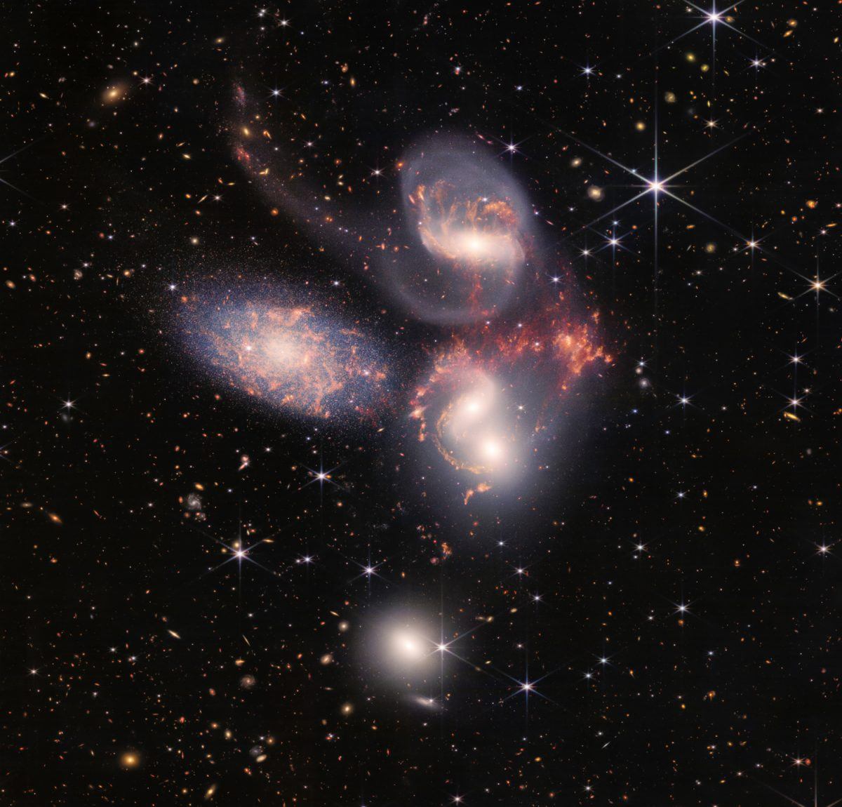 Un grupo de cinco galaxias adyacentes, con estrellas y otras galaxias visibles desde la distancia.