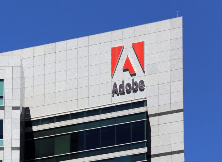The Adobe logo on a large building against a blue sky.