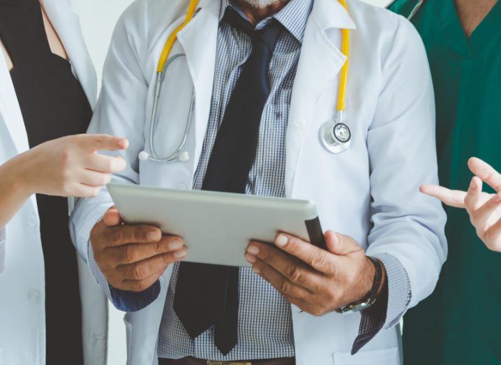 Group of doctors looking at a tablet.