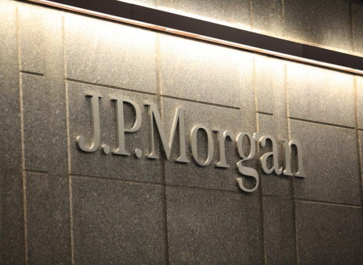The JP Morgan logo on a grey building wall with a line of lighting above it.