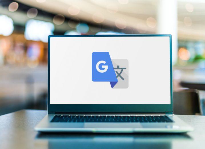 Google Translate logo on a laptop screen, with a blurred interior in the background.