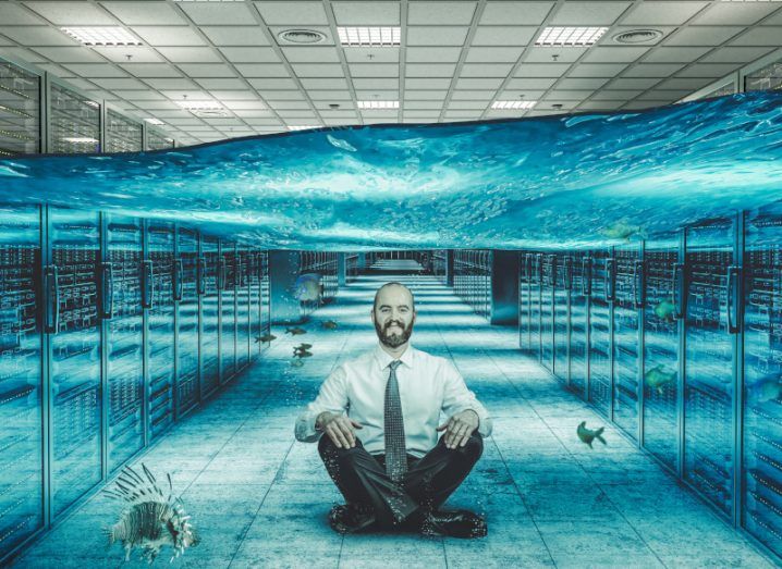 A man sitting in a data centre full of water. A concept image for an underwater data centre.