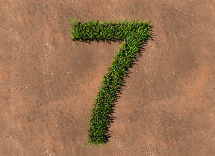 A number seven made out of grass on a brown surface.