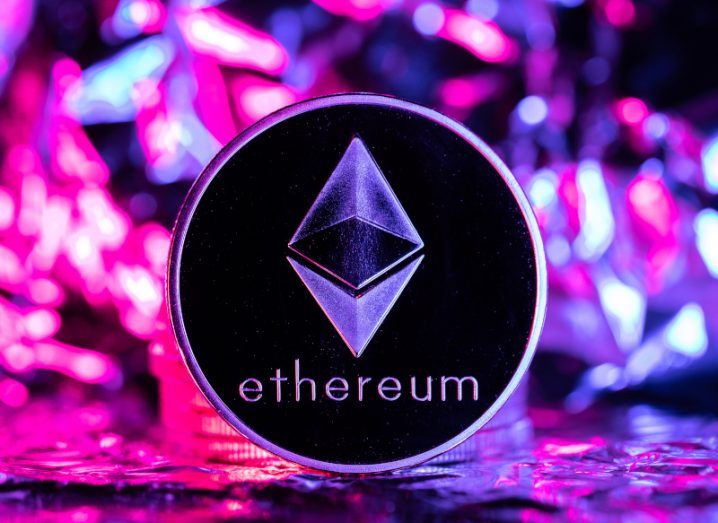 A coin with the Ethereum logo on it, with different coloured shapes in the background.