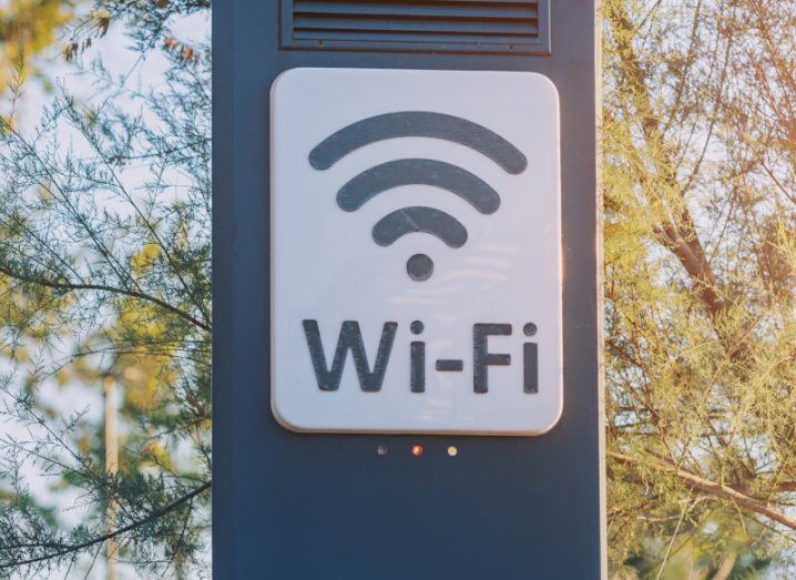 A Wi-Fi logo on a frame, with trees and a sky in the background.