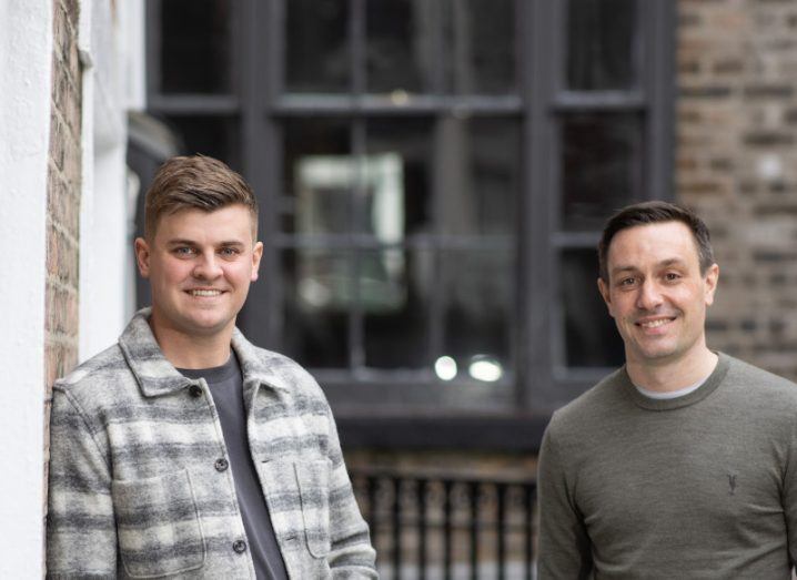 The founders of Wayflyer stand outside a brick building.