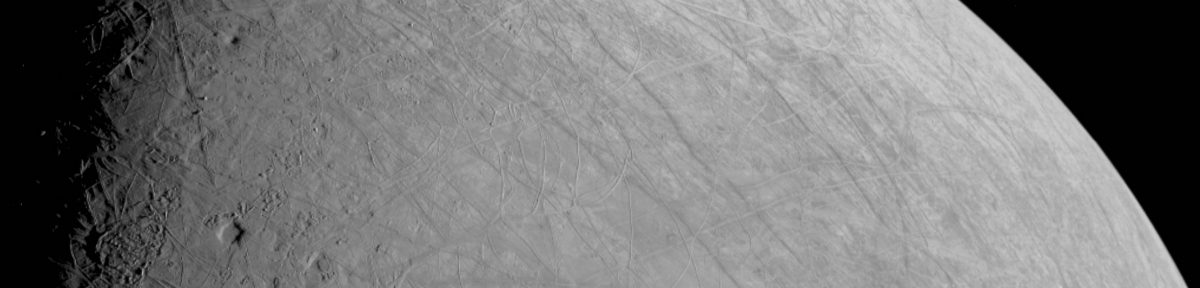 An image of the surface of a moon, with empty space visible on the right. Craters and dusty lines are visible on the moon's surface. The moon is Europa, with the image taken by NASA's Juno spacecraft.