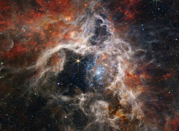 An image of the Tarantula Nebula, with dust and stars visible in the image. Taken from the James Webb Space Telescope.