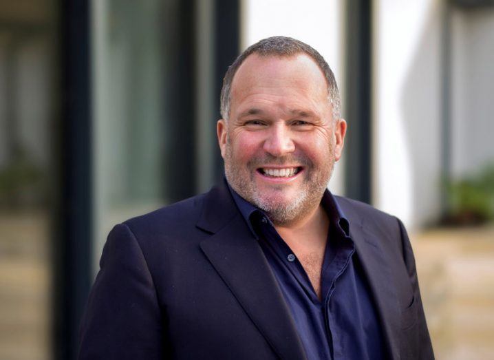 Headshot of a smiling man in a suit.