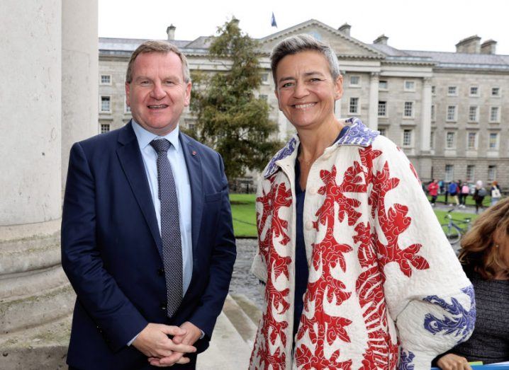 Ibec CEO and Margarethe Vestager stand next to each other in front of a building in Trinity College Dublin.