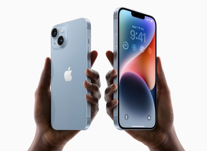 The iPhone 14 and iPhone 14 Plus models held in two people's hands.