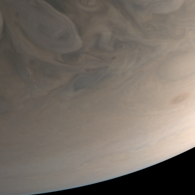 Cloudy surface of Jupiter with dull patterns and the horizon visible in the bottom right corner.