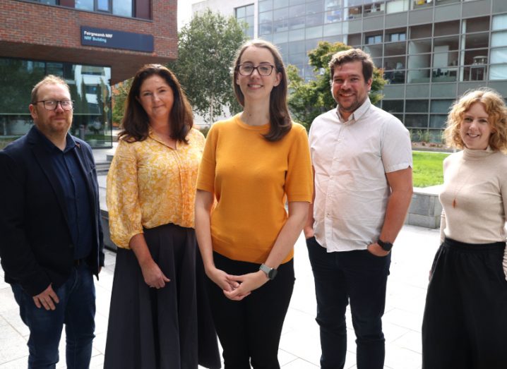Three men and two women standing together in front of some buildings at Dublin City University. They are the Grain-4-Lab team, working to reduce plastic use in labs.