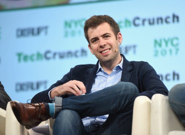 Oisin Hanrahan sits on stage at a tech conference.