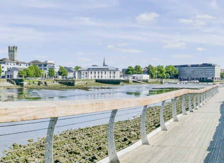 A view of the Shannon promenade in Limerick with buildings across the river visible from a boardwalk.