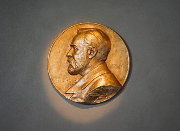 A Nobel Prize medal sits against a grey background.