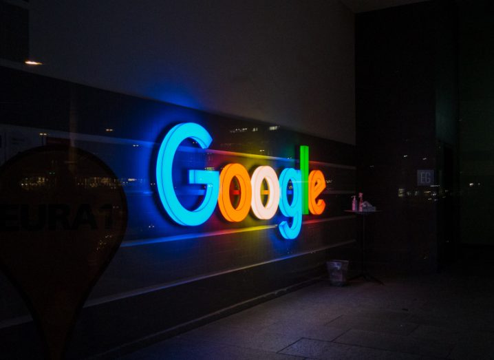 Google logo lit up at night on the side of a building, with blue, red, yellow and green colours on different letters.