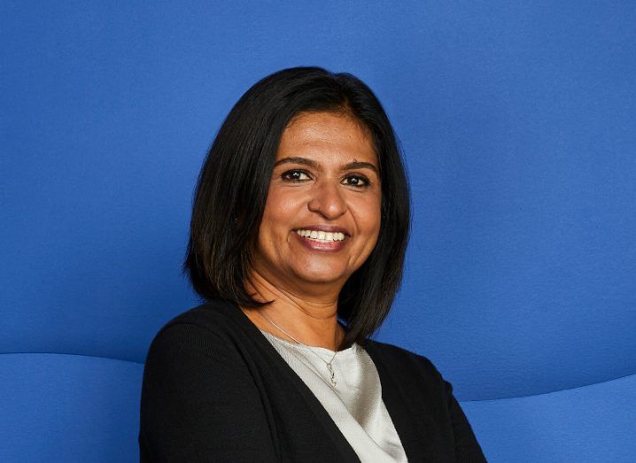 A headshot of Archana Rao on a blue background.