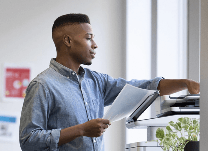 A man putting documents on a printer.