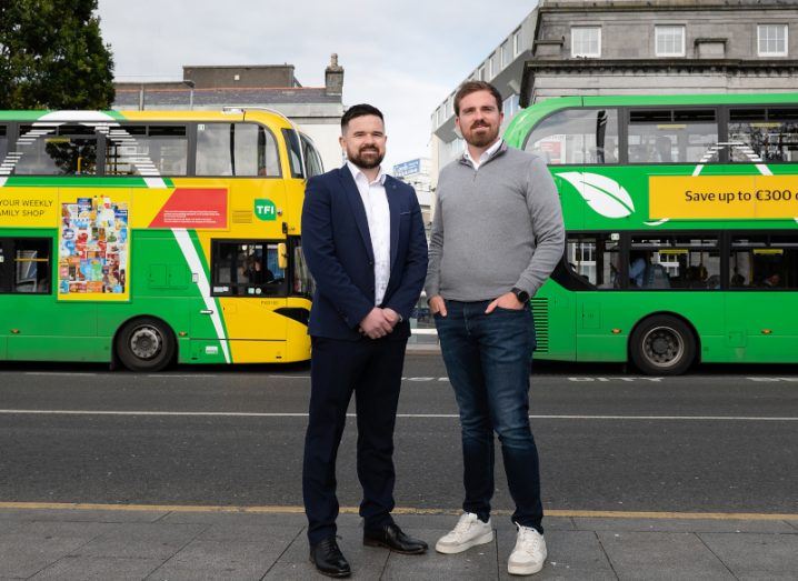 Alan Farrelly and Brian O'Rourke, CitySwift standing outside on the street with two buses behind them.