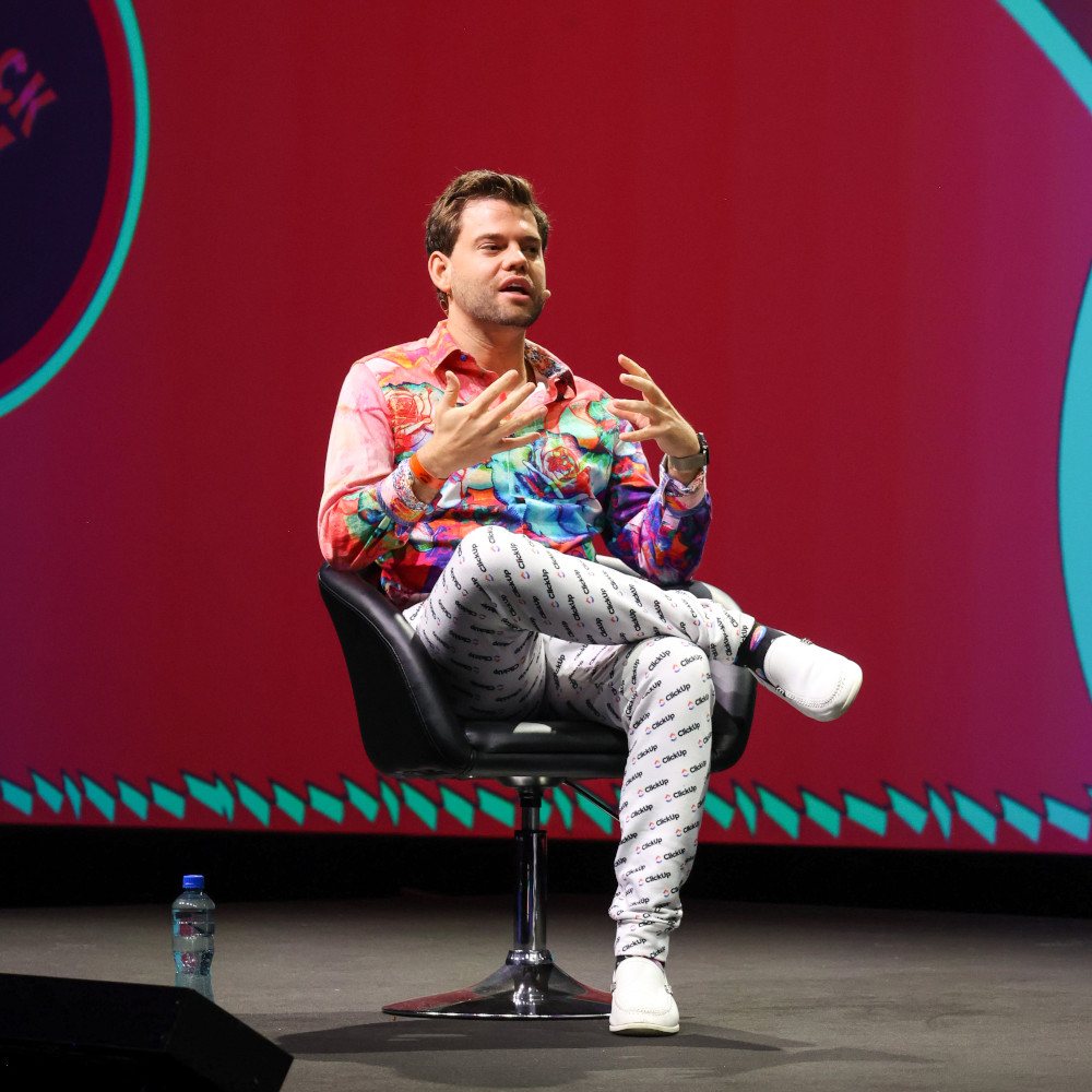 Zeb Evans, CEO and founder of ClickUp sitting in a chair on stage at SaaStock, Dublin.