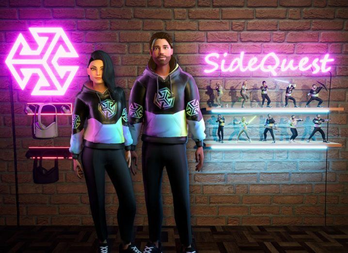 Two virtual avatars standing next to a neon pink sign on a wall that reads 'SideQuest'.