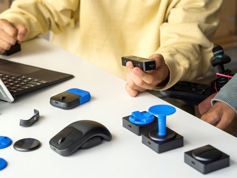 Different adaptive accessories are laid on on a desk.