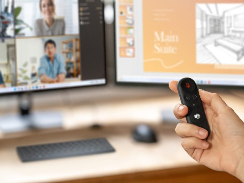 A person's hand is holding the Microsoft Presenter+ remote.