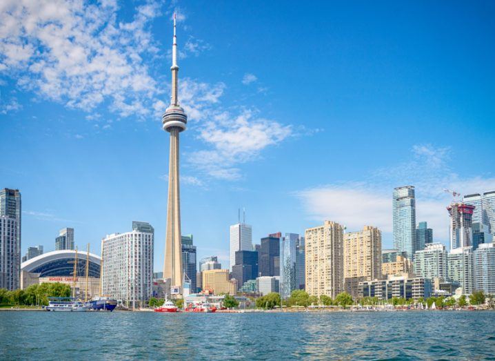 The Toronto skyline with buildings and an iconic tower visible from the lake Ontario.