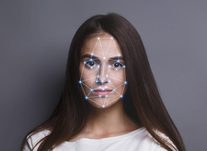 A woman looking straight ahead with lines around her face. Used to represent biometric surveillance technology, such as facial recognition software.