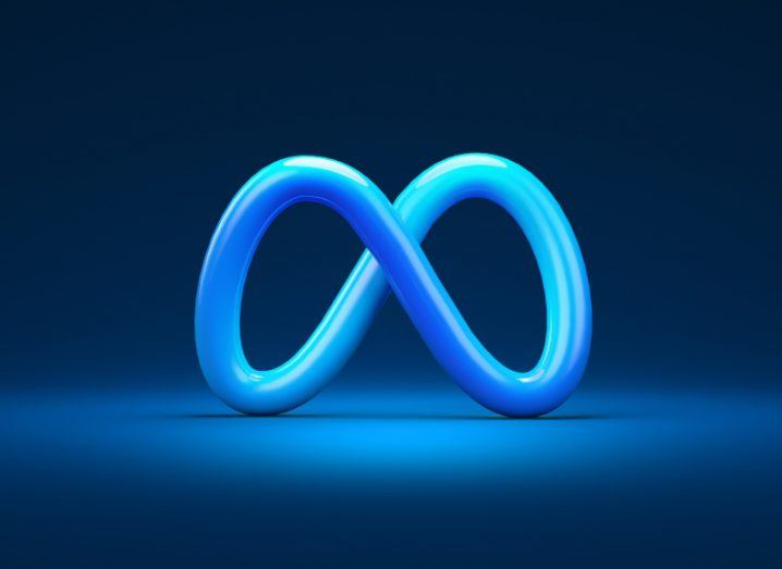Illustration of a blue Meta logo on a blue surface, with a dark background.
