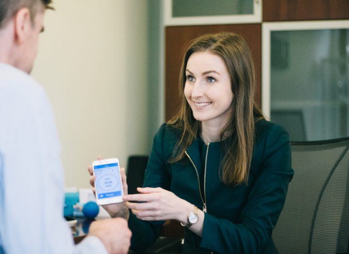 Ciara Clancy sits in an office with the Beats Medical app open on her phone.