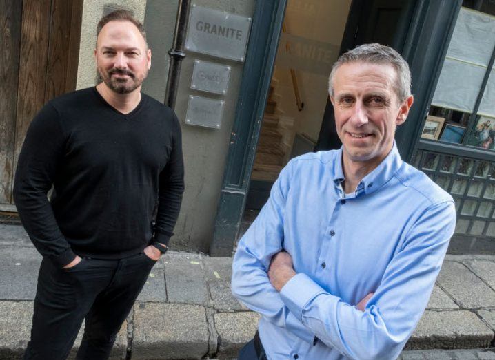 Colin Meagle, CEO of Continuum, and Conor Buckley, CEO of Granite Digital, standing outside a building with Granite's name on a plaque on the wall.