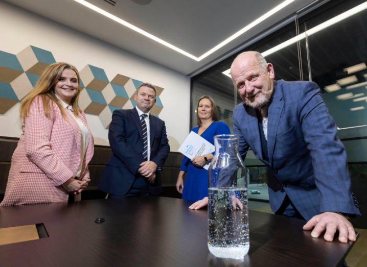 Two men and two women standing at a table that has a bottle full of water. The people are present for the launch of a Hydrogen Ireland report on the potential of green hydrogen.