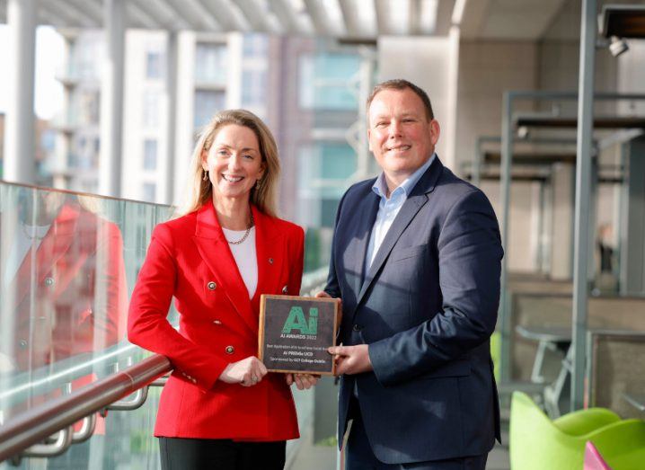 A woman and a man stand next to each other holding an AI Ireland award.