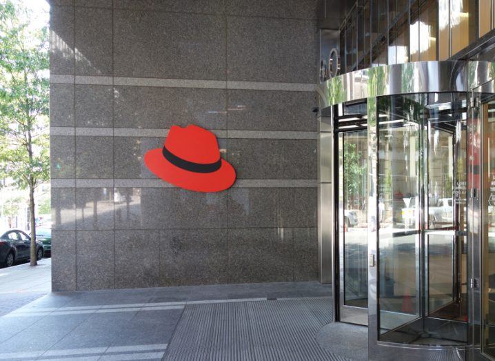 Red Hat logo in front of the entrance to a building with revolving door.