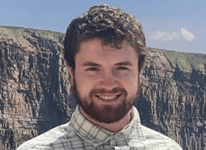 Jason Curran of UL stands in front of scenic cliffs.